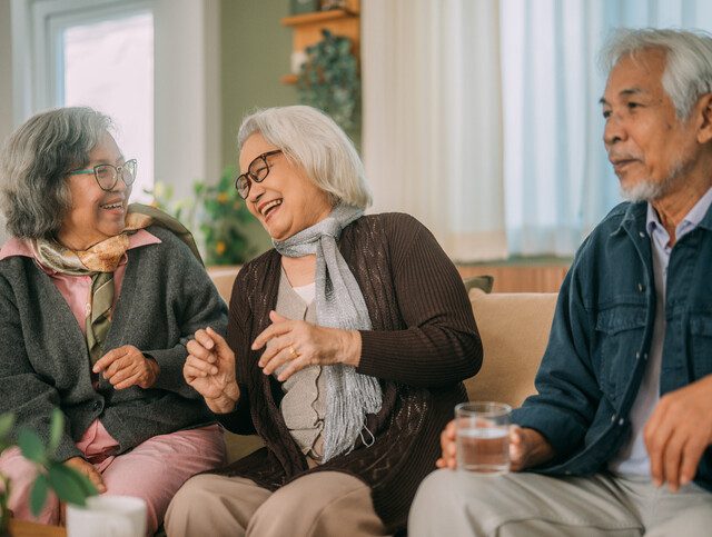 Three senior friends sitting together on a couch