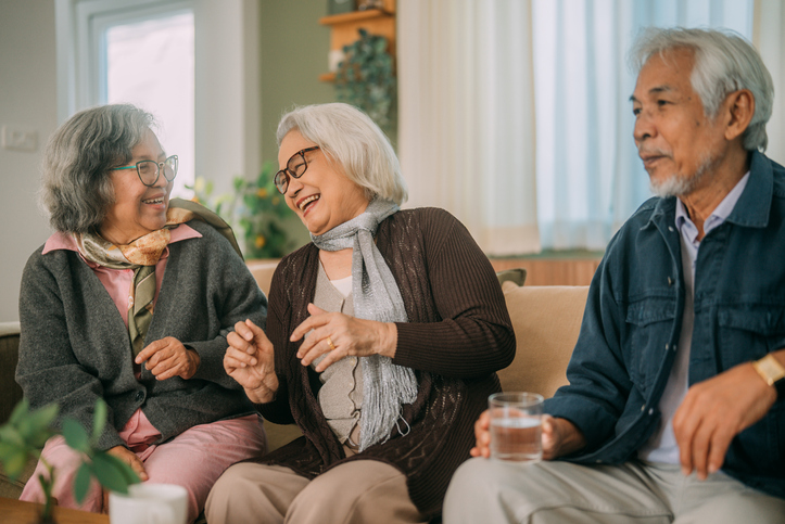 Three senior friends sitting together on a couch